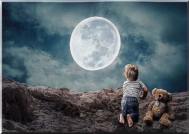 child in front of the moon