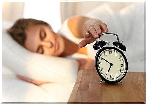 woman turning off her alarm clock