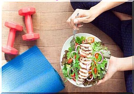 A woman eating a plate of salad. 